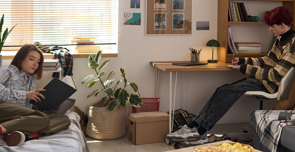 Jeune étudiant concentré écrivant dans un carnet dans un café dublinois lumineux, ambiance studieuse naturelle